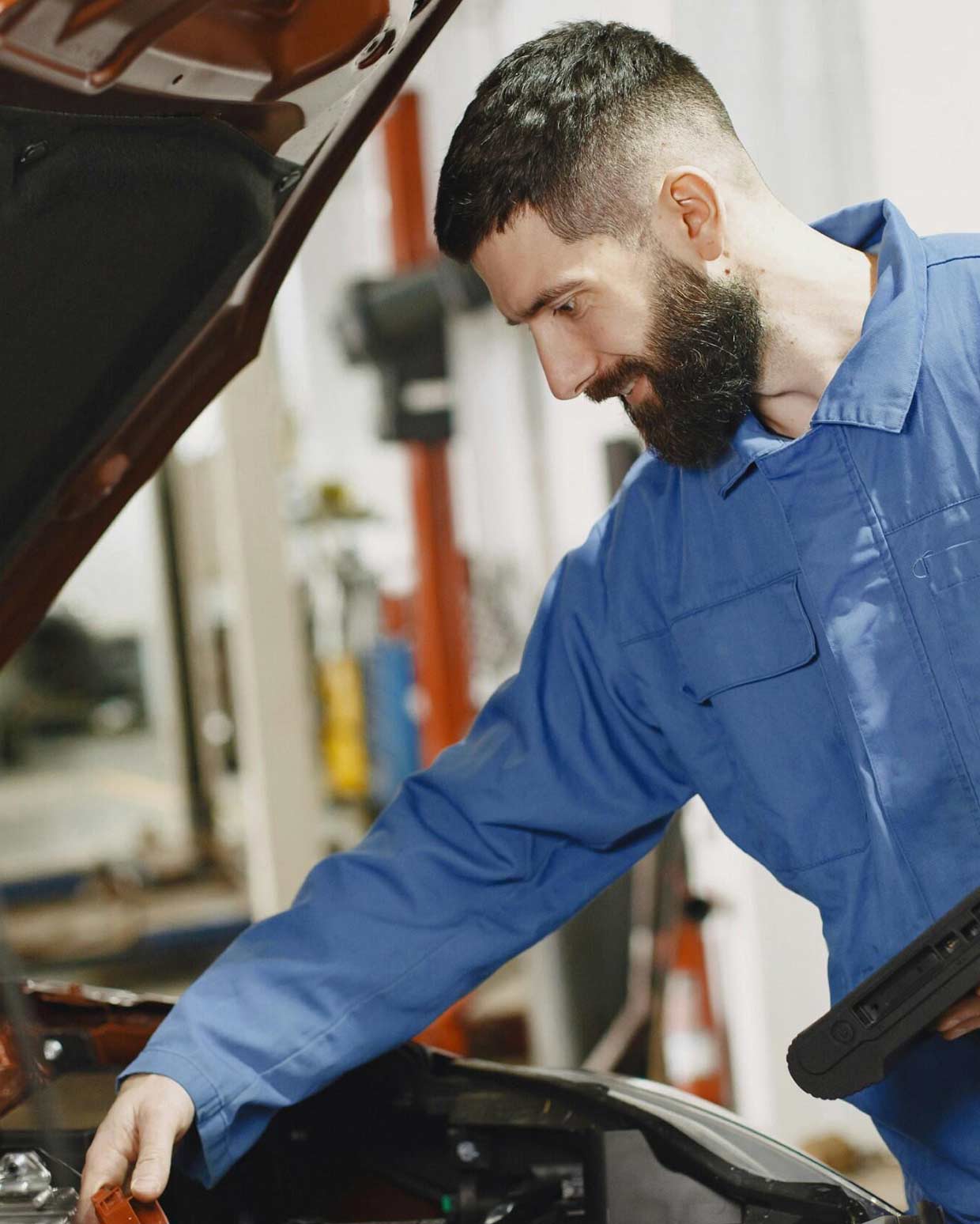 Autoexperte analysiert Technik im Frontbereich eines Fahrzeugs