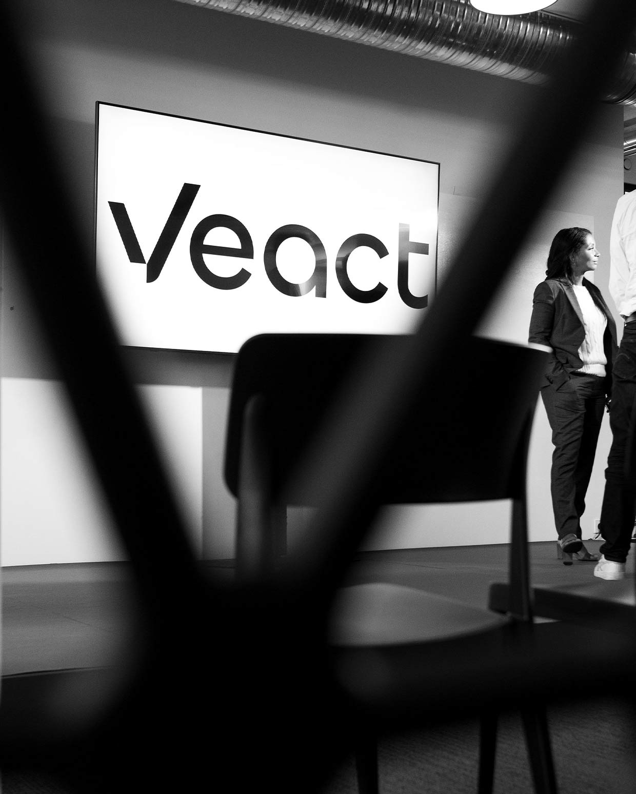 Team bei der Planung digitaler Lösungen mit unscharfen "V" im Vordergrund