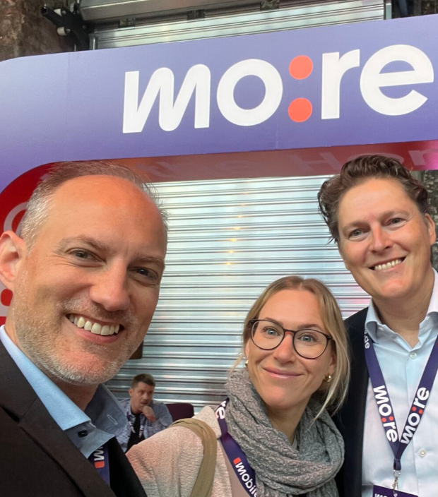 Tina Makowski und Philipp Messmann von Veact gemeinsam mit einem Kollegen vor dem more mobile de Messestand