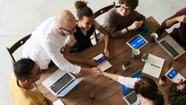 Teammeeting mit Tablets und Laptops zur Planung datengetriebener Marketing Strategien und Customer Journeys