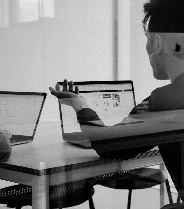 Team analysiert Daten auf Laptops in einem Meeting als Symbol für datengetriebte Zusammenarbeit