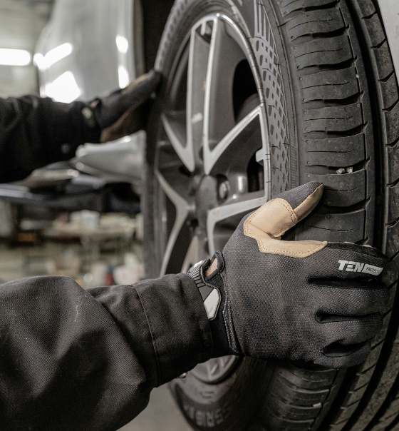 Mechaniker prüft einen Autoreifen in der Werkstatt während eines Reifenservices